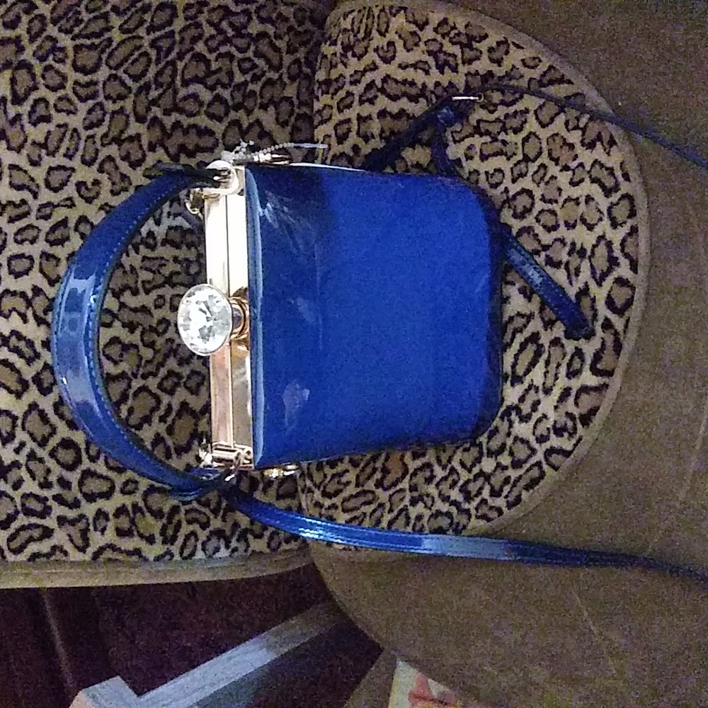 A blue patient crossbody bag with Gold Hardware